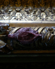 Red coloured moulded flower on a frame. A step in the process of repairing a badly damaged frame.